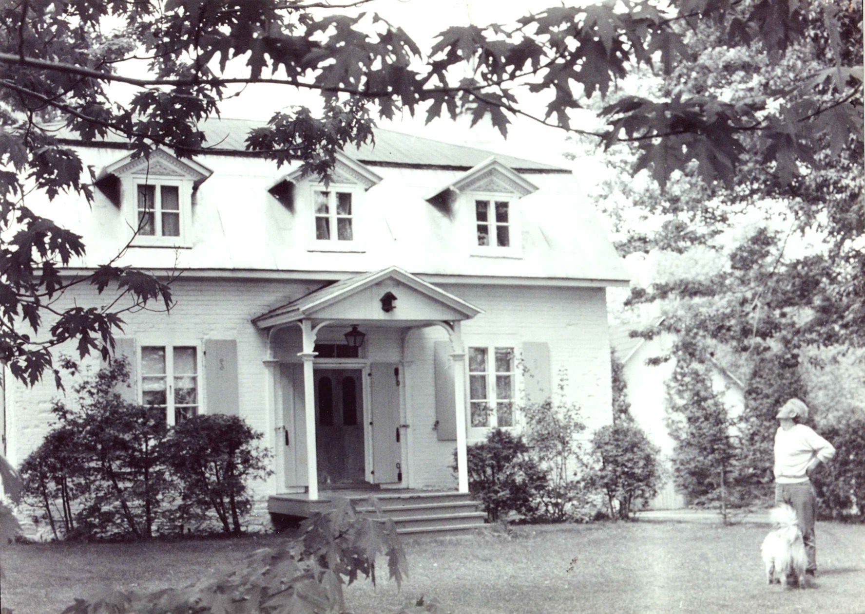 Flix Leclerc avec son chien devant sa maison, chemin de l'Anse (1950) Collection du  Muse de Vaudreuil-Soulanges.